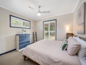 a bedroom with a bed and a dresser and a window at 1 - 11 Roslin Street Moffat Beach QLD in Caloundra