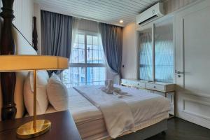 a bedroom with a large bed with a window at Grand Florida 1 Bedroom Condo close to Beach - G511 in Na Jomtien +20 photos