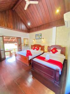 a bedroom with two beds with red pillows at Luangprabang Villa Kee Lee in Luang Prabang