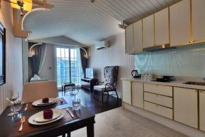 eine Küche mit Tisch und ein Esszimmer in der Unterkunft Grand Florida 1 Bedroom Condo close to Beach - G601 in Na Jomtien