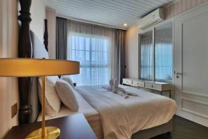 ein Schlafzimmer mit einem großen Bett und einem großen Fenster in der Unterkunft Grand Florida 1 Bedroom Condo close to Beach - G601 in Na Jomtien + 23 Fotos