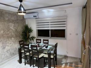 a dining room with a table and chairs and a window at 2Bed Abidjan Apartment- Relax Explore & Unwind in Cocody +11 photos