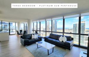 メルボルンにあるMelbourne Lifestyle Apartments - Best Views on Collinsのソファとテーブルのあるリビングルーム