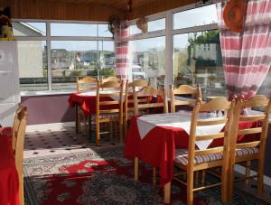 uma sala de jantar com mesas e cadeiras e uma janela em Ceecliff House em Culdaff