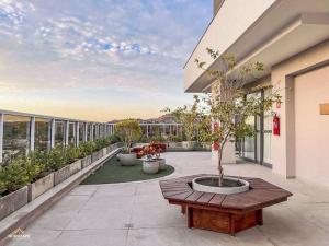 - une terrasse avec une table et un arbre dans un bâtiment dans l'établissement Nosso Apê 915: Piscina | TV Box | Academia - NA2002, à Juiz de Fora