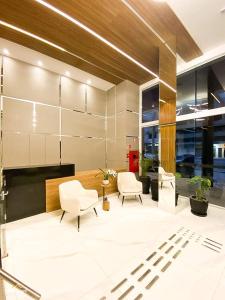 un salon avec deux chaises et une table dans l'établissement Nosso Apê 915: Piscina | TV Box | Academia - NA2002, à Juiz de Fora