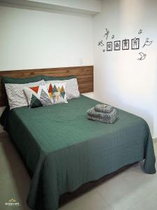 une chambre avec un lit avec une couette verte dans l'établissement Nosso Apê 915: Piscina | Academia | Coworking - NA2103, à Juiz de Fora 38 autres photos
