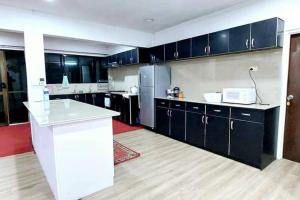 a kitchen with black cabinets and a white counter top at Shuhil Holiday Home in Lautoka