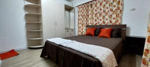 a small bedroom with a bed with orange pillows at Shuhil Holiday Home in Lautoka