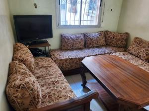 à 10 minutes du grand mall d'Afrique, WiFi Netflix 1ère étage في Oulad Hamida: غرفة معيشة بها أريكة وطاولة