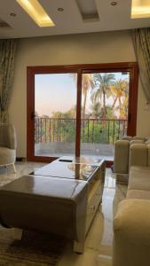 a living room with a bed and a large window at Luxor Apparment in Al Bayāḑīyah