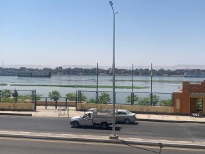 a white truck parked on the street next to a river at Luxor Apparment in Al Bayāḑīyah