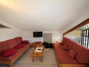 a living room with red couches and a flat screen tv at Duplex lumineux 4 pièces, 10 pers, rénové au pied des pistes - Auris en Oisans - FR-1-297-341 in Auris