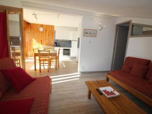 a living room with two red chairs and a table at Duplex lumineux 4 pièces, 10 pers, rénové au pied des pistes - Auris en Oisans - FR-1-297-341 in Auris