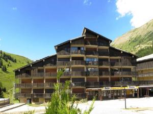a large building with mountains in the background at Duplex lumineux 4 pièces, 10 pers, rénové au pied des pistes - Auris en Oisans - FR-1-297-341 in Auris