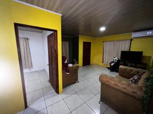 a living room with two couches and a television at Coconut Casa 10 Min from La Fortuna with AC - Fast Wi-Fi - Private Parking in a Friendly Neighborhood in Fortuna +2 photos