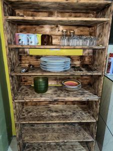 a wooden shelf with plates and dishes on it at Coconut Casa 10 Min from La Fortuna with AC - Fast Wi-Fi - Private Parking in a Friendly Neighborhood in Fortuna