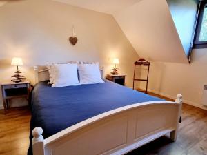una camera da letto con un grande letto con lenzuola blu e cuscini bianchi di Gîte au calme avec jardin, Wifi et parking près de Lille - FR-1-510-222 a Fournes-en-Weppes