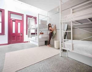 a woman is standing in a bedroom with bunk beds at Little Drifter Surry Hills in Sydney