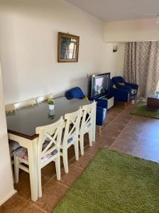 a living room with a table and chairs and a couch at Blumar El sokhna in Al Ḩafāʼir +11 photos