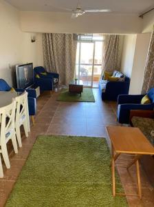 a living room with a couch and a tv at Blumar El sokhna in Al Ḩafāʼir