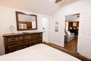 a bedroom with a dresser and a mirror at The Caroline Suite in Key West