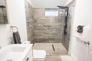 a bathroom with a shower with a toilet and a sink at The Caroline Suite in Key West +3 photos