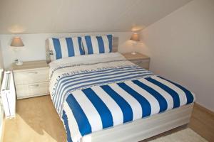 ミッデルケルケにあるVakantievilla Aan Zeeのベッドルーム1室(青と白のストライプのベッド1台付)