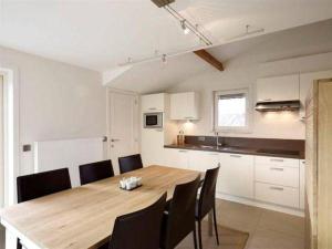 Una cocina y un comedor con mesa y sillas de madera. en Vakantievilla Aan Zee, en Middelkerke