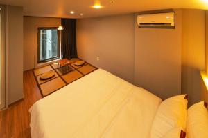 a bedroom with a large white bed and a window at Shinchon Mayven Hotel - Foreign Tourist Tax Return Hotel in Seoul +14 photos