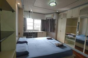 a bedroom with two beds in it with a kitchen at 繁华与幽静的联排别墅 近帕蓝9,拉猜达地铁站,订5晚免费接机一趟 in Ban Na Song