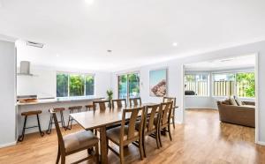 a dining room and living room with a table and chairs at Cheerful 4-bedroom family retreat in Caves Beach in Caves Beach
