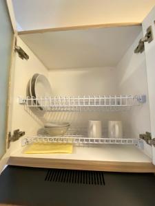 RawalembangRelaxing and Cozy Studio Tokyo Riverside PIK 2 Apartment By Travelio的厨房里有架子的开放式冰箱