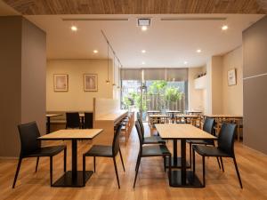 a dining room with wooden tables and chairs at Hotel Vista Nagoya Nishiki in Nagoya