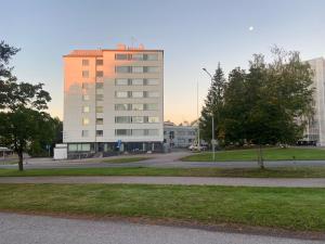 ヒュヴィンカーにあるApartment next to the railway stationの公園のある都市の白い高い建物