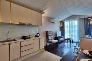 eine Küche mit weißen Schränken und ein Wohnzimmer in der Unterkunft Grand Florida 1 Bedroom Condo close to Beach - G610 in Na Jomtien