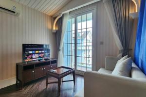 ein Wohnzimmer mit Couch und großem Fenster in der Unterkunft Grand Florida 1 Bedroom Condo close to Beach - G610 in Na Jomtien