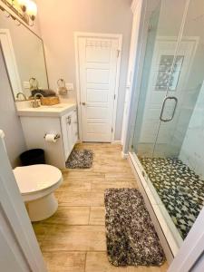 a bathroom with a shower and a toilet and a sink at South Texas Getaway King Size & Double Queen in Brownsville +48 photos
