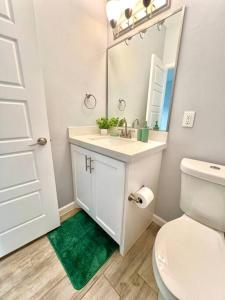 a bathroom with a sink and a toilet and a mirror at South Texas Getaway King Size & Double Queen in Brownsville