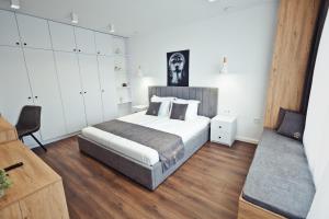 ein Schlafzimmer mit einem Bett und einem Stuhl darin in der Unterkunft AGIA- luxury apartment Sofia in Sofia