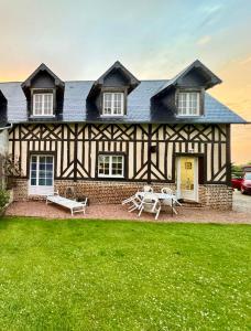 a house with a green lawn in front of it at La Longere du Haras in Manerbe