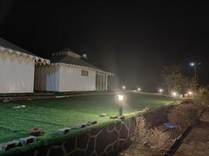 a building at night with lights in the yard at The Purple County - Homestay in Lonavala