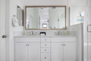 une salle de bain blanche avec deux lavabos et un miroir dans l'établissement Better Two-Gether 2-bed 2,5-bath, à Oceanside