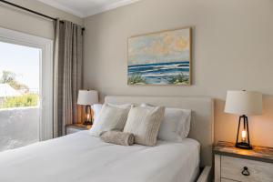 a bedroom with a white bed with two lamps and a window at Carlsbad Village Escape 3-Bed 2,5-Bath steps from the beach in Carlsbad