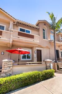 a house with a red umbrella in front of it at Carlsbad Village Escape 3-Bed 2,5-Bath steps from the beach in Carlsbad
