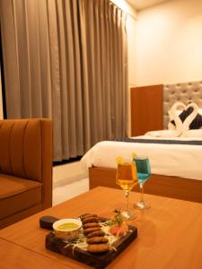 奇陶尔加尔Hotel Pride Of Chittor的一间酒店客房,配有一张桌子,提供食品和饮料托盘