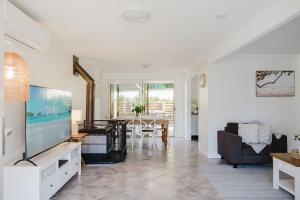 a living room with a television and a dining room at Our Molly in Mollymook