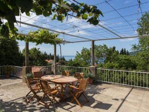 een houten tafel en stoelen op een terras bij Apartments Anka - One-Bedroom Apartment with Balcony and Sea View in Trsteno