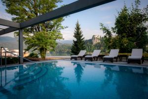 ブレッドにあるRikli Balance Hotel – Sava Hotels & Resortsの山々の景色を望むスイミングプール(椅子付)