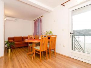 a dining room with a table and chairs and a couch at Apartments Ere Zuronja-One-Bedroom Apartment with Sea View 3 in Putniković
